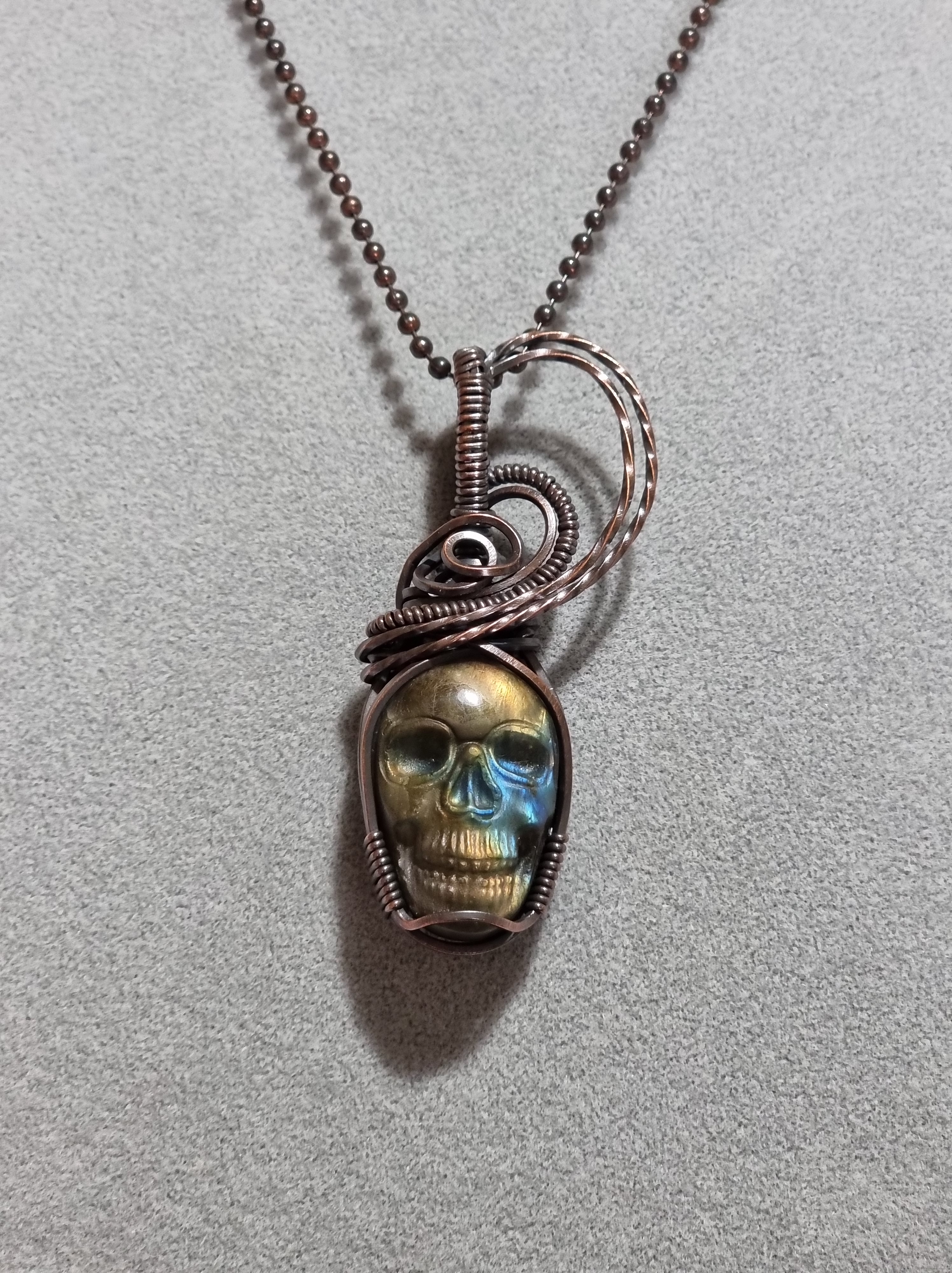 Beautiful carved Labradorite skull pendant in antique copper wire.